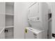 A laundry room is shown with stacked washer and dryer units and shelving for storage at 9865 Bright Angel Way, Las Vegas, NV 89149