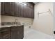 The laundry room boasts granite countertops, wood cabinets, and tiled flooring at 9865 Bright Angel Way, Las Vegas, NV 89149