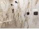 Contemporary shower features dual shower heads, a built-in bench, and marble style tile at 9865 Bright Angel Way, Las Vegas, NV 89149