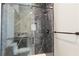 Contemporary glass-enclosed shower showcasing dark, veined marble, modern fixtures, and pebble flooring at 9865 Bright Angel Way, Las Vegas, NV 89149