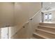 Bright staircase featuring wooden steps, white handrail, leading to a doorway with a ceiling fan and exterior view at 9865 Bright Angel Way, Las Vegas, NV 89149