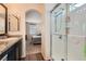 Bathroom with wood floors, granite countertops, shower, sink and view into adjacent bedroom at 987 Wembly Hills Pl, Henderson, NV 89011