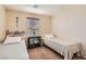 Bedroom with two twin beds, side table and chair near a window with blinds at 987 Wembly Hills Pl, Henderson, NV 89011