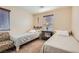 Bedroom with two twin beds, side table and chair near a window with blinds at 987 Wembly Hills Pl, Henderson, NV 89011