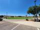 Expansive community green space with mature trees, a walkway, and parking under a clear sky at 987 Wembly Hills Pl, Henderson, NV 89011
