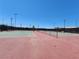 View of empty tennis courts with lighting, providing ample space for recreational activities at 987 Wembly Hills Pl, Henderson, NV 89011