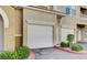 Attached two-car garage with a white door, surrounded by neatly maintained landscaping at 9975 Peace Way # 1069, Las Vegas, NV 89147