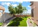 Landscaped backyard with synthetic grass, stone mulch, and privacy wall for low maintenance at 1016 Eaglewood Dr, Las Vegas, NV 89144