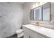 Modern half bath featuring hexagon tile walls, and a lighted, mirrored vanity at 1016 Eaglewood Dr, Las Vegas, NV 89144