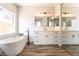 Modern bathroom featuring dual sink vanities, soaking tub, and stylish mirrors and lighting at 1016 Eaglewood Dr, Las Vegas, NV 89144
