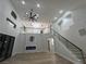 Open-concept living space with high ceilings, a fireplace, and a staircase with glass railings at 1016 Eaglewood Dr, Las Vegas, NV 89144