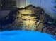 A stunning custom rock waterfall is featured in this pool with built-in lighting effects at 1016 Eaglewood Dr, Las Vegas, NV 89144