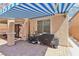 Outdoor kitchen area with a striped awning and cooking appliances on a brick patio at 10329 Walworth Ave, Las Vegas, NV 89166