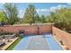 Wide angle of backyard with a basketball court, seating area, lush trees, and perimeter block wall at 10329 Walworth Ave, Las Vegas, NV 89166