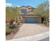 Two story home with a three-car garage, manicured landscaping, and stone accents at 10329 Walworth Ave, Las Vegas, NV 89166