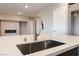 Close-up of a kitchen island sink with a stainless steel faucet and fireplace in the background at 128 Los Cabos Dr # 301, Las Vegas, NV 89144