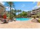 Lush pool area surrounded by palm trees, lounge chairs, and elegant architecture at 128 Los Cabos Dr # 301, Las Vegas, NV 89144