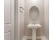 Elegant powder room with a pedestal sink, oval mirror, and modern fixtures at 128 Los Cabos Dr # 301, Las Vegas, NV 89144