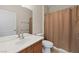Bathroom featuring a large mirror, vanity, toilet, towel rack, and shower with tan shower curtain at 1407 Wheelwright Ct, Mesquite, NV 89034