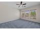 Carpeted bedroom with ceiling fan and multiple windows offering natural light and outdoor views at 1407 Wheelwright Ct, Mesquite, NV 89034