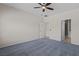 Spacious carpeted bedroom featuring ceiling fan and access to bathroom and walk-in closet at 1407 Wheelwright Ct, Mesquite, NV 89034