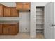 Bright kitchen showcases wooden cabinetry and a convenient, well-lit pantry with shelving at 1407 Wheelwright Ct, Mesquite, NV 89034