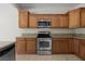 Well-lit kitchen features stainless steel appliances, granite countertops, and beautiful wood cabinetry at 1407 Wheelwright Ct, Mesquite, NV 89034