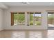 Bright living room featuring tan tile floors and two large windows with golf course views at 1407 Wheelwright Ct, Mesquite, NV 89034