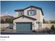 Charming two-story home with a two-car garage, stylish blue accents, and desert landscaping at 1425 Gable Falls Dr # 93, North Las Vegas, NV 89084