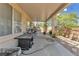 Covered patio with exercise equipment and BBQ with views of the landscaped backyard at 1476 Evening Song Ave, Henderson, NV 89012