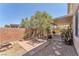 Landscaped backyard featuring a large tree, gravel, pavers, and a covered patio at 1476 Evening Song Ave, Henderson, NV 89012