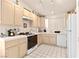 Bright kitchen featuring light-colored cabinetry, tile countertops, and modern appliances at 1728 Crystal Chimes Dr, Las Vegas, NV 89106