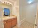 Bathroom with a single sink vanity, large mirror, and a bathtub with white tile surround at 1951 Teepee Rd, Pahrump, NV 89048