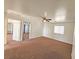 Spacious bedroom with a ceiling fan, neutral carpet, and multiple doorways leading to closets or other rooms at 1951 Teepee Rd, Pahrump, NV 89048