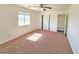 Sunlit bedroom with neutral carpet, a ceiling fan, a window, and closet space with doors at 1951 Teepee Rd, Pahrump, NV 89048