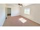 This bedroom features neutral carpet, ceiling fan, a window and an entrance to an additional room at 1951 Teepee Rd, Pahrump, NV 89048