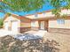 Charming townhome featuring a stone facade, a two-car garage, and mature trees for shade and curb appeal at 1951 Teepee Rd, Pahrump, NV 89048