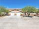 Inviting townhome exterior featuring a two-car garage, desert landscaping, and a well-maintained facade at 1951 Teepee Rd, Pahrump, NV 89048
