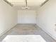 View of the garage showing the cement floor, lighting fixture, hardware and door to outside at 1951 Teepee Rd, Pahrump, NV 89048