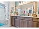 Bathroom with double sink vanity, granite countertops, wood cabinets, decorative mirror and a shower-tub combination at 2225 Chandler Ranch Pl, Laughlin, NV 89029