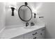Elegant powder room with white vanity, marble countertop, black hardware, and stylish wall-mounted lighting fixtures at 2250 Bowie Cir, Henderson, NV 89014