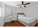 Cozy bedroom with desk area, wood floors, ceiling fan, white trim and natural light at 2250 Bowie Cir, Henderson, NV 89014