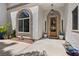 Elegant home entrance with arched window, custom wood door, and manicured landscape at 2250 Bowie Cir, Henderson, NV 89014