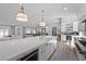 Open-concept kitchen and living area showcasing a large marble island, white cabinetry and stainless steel appliances at 2250 Bowie Cir, Henderson, NV 89014