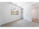 Clean bedroom with a closet, large window, and light-colored carpet showcasing a modern, minimalist style at 2501 Indigo Mountain St, Henderson, NV 89044