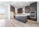 Contemporary kitchen with stainless appliances, dark wood cabinets, center island, and wood flooring at 2501 Indigo Mountain St, Henderson, NV 89044