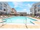 Stunning community pool with lounge chairs and umbrellas surrounded by modern residential buildings and sunny skies at 2501 Indigo Mountain St, Henderson, NV 89044