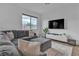 Comfortable living room with a gray sectional, large window, and modern entertainment setup at 2699 Chance Canyon St, Henderson, NV 89044