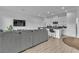Well-lit open concept living space with a modern gray sofa and kitchen island, featuring white cabinets at 2699 Chance Canyon St, Henderson, NV 89044