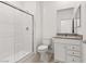 Bathroom featuring a sleek shower with glass doors, modern vanity, mirror, and toilet at 2727 Avril Point St, Las Vegas, NV 89156